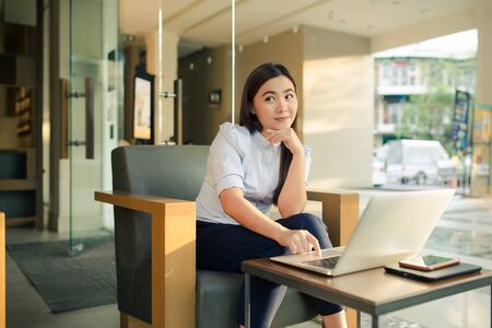 Happy woman using laptop in cafeの写真素材