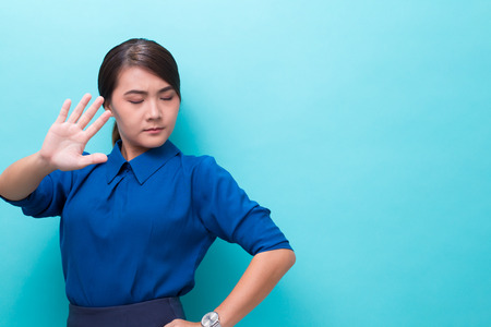 Serious woman showing hand stop gesture on isolated backgroundの写真素材