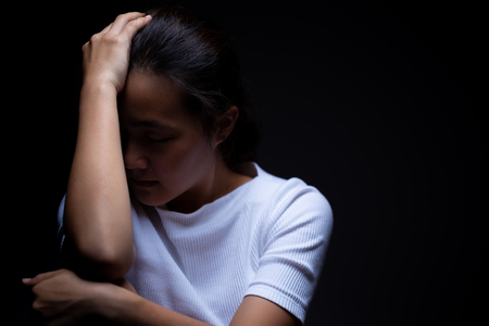 Sadness of a woman in the darkの写真素材