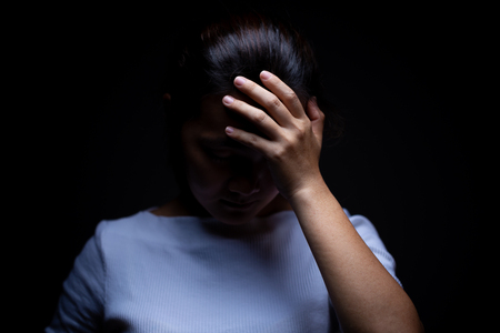 Sadness of a woman in the darkの写真素材