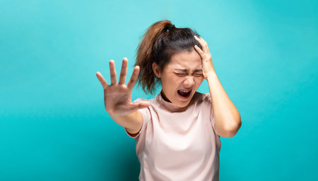 Portrait of angry woman standing on blue background