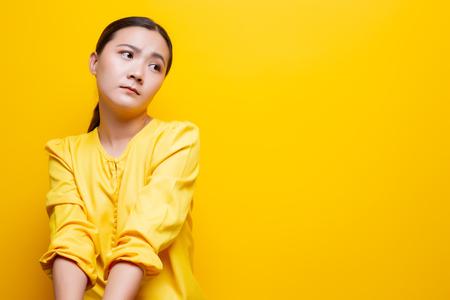 Sad woman isolated over yellowの写真素材