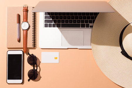 Laptop and smart phone with items for vacation time over isolatedの写真素材