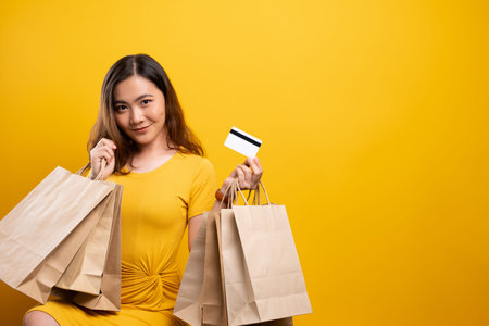 Portrait of woman holding shopping bags and credit card isolated over background