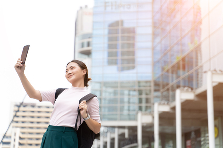 Happy asian woman taking a selfie in the cityの写真素材