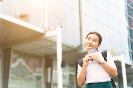 Happy woman using smart phone in the cityの写真素材
