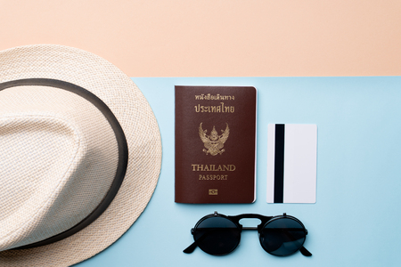 Top view travel concept with passport, credit card, sunglasses and hat on abstract beach backgroundの写真素材