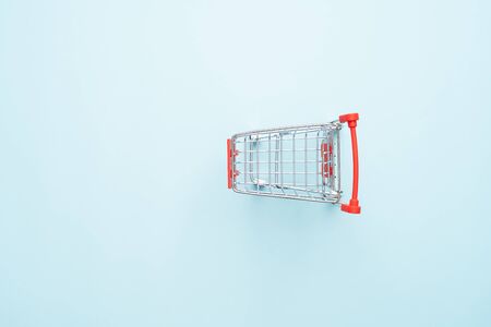 Shopping cart isolated on blue backgroundの写真素材