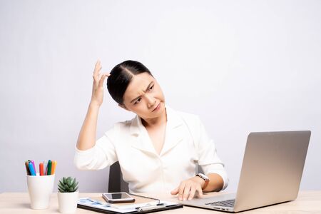 Woman scratching her head at office isolated white backgroundの写真素材