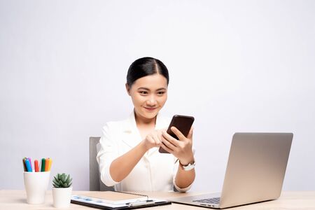 Portrait of happy woman used smartphone at office isolated over backgroundの写真素材