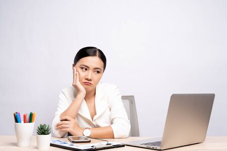 Bored woman at office working with a laptop isolated over backgroundの写真素材