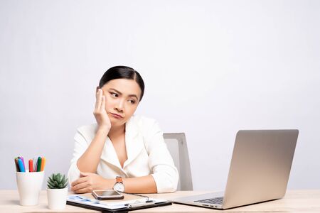 Bored woman at office working with a laptop isolated over backgroundの写真素材