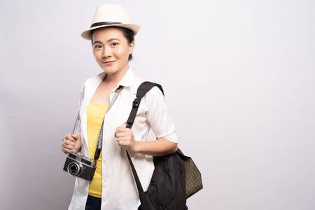 Happy woman holding camera over background and looking at cameraの写真素材