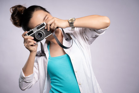 Happy woman take a photo by camera isolated over background