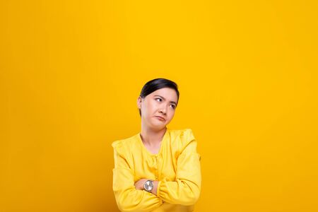 Angry woman standing isolated over yellow backgroundの写真素材
