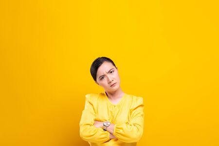 Angry woman standing isolated over yellow backgroundの写真素材