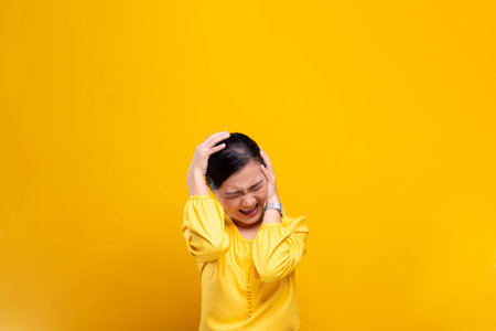 Angry woman screaming isolated over yellow background