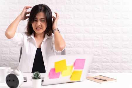 Woman scratching her head at officeの写真素材