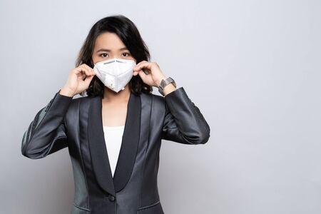 Businesswoman wearing the N95 mask isolated over white backgroundの写真素材