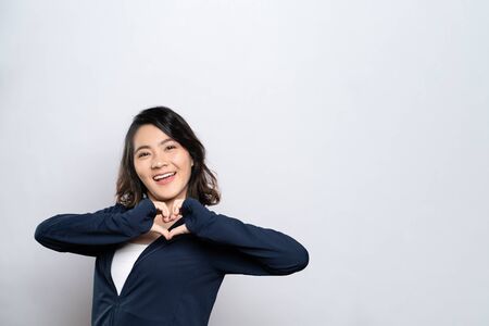 Portrait of a healthy woman in love making love symbol isolated over white backgroundの写真素材