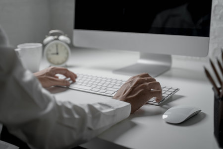 Close up shot of businessman use computer typing message on keyboardの写真素材
