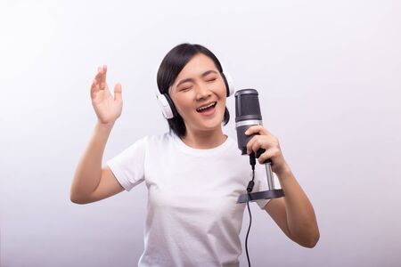 Happy woman with headphones and singing a songの写真素材