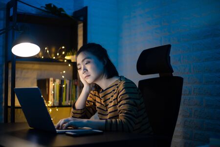 Asian woman tired and take a nap after overwork overtime at home. WFH. Work from home for avoid the Coronavirus COVID 19 concept.の写真素材