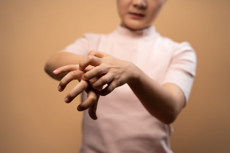Asian woman was sick with irritate itching her skin, scratching her skin, standing isolated on beige...