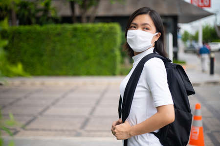 Asian woman happy smiling wearing protective face mask prevention virus and pollution, walking to department store for shopping. New lifestyle with Corona Virus COVID-19.の写真素材