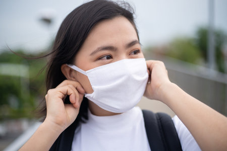 Asian woman happy smiling wearing protective face mask prevention virus and pollution, walking to...