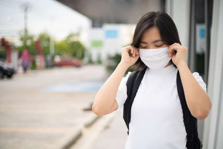 Asian woman happy smiling wearing protective face mask prevention virus and pollution, walking to department store for shopping. New lifestyle with Corona Virus COVID-19.の写真素材