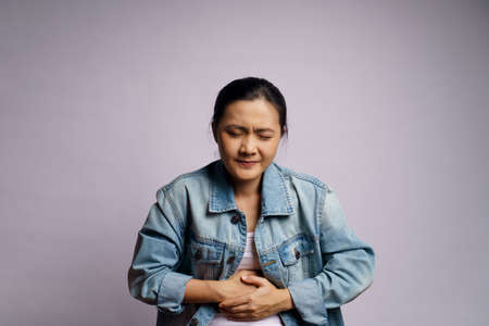 Asian woman was sick with stomach ache standing isolated on white background.の写真素材