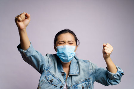 Asian woman wearing protective face mask shouting isolated on white background.