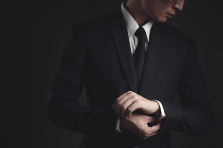 Close up shot of businessman in black suit. Elegant handsome on black background.の写真素材