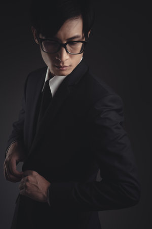 Close up shot of businessman in black suit. Elegant handsome on black background.の写真素材