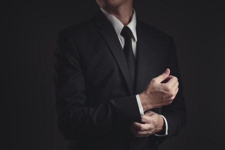 Close up shot of businessman in black suit. Elegant handsome on black background.の写真素材
