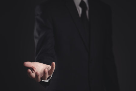 Close up shot of businessman fight and win in black suit. Elegant handsome on black background.の写真素材