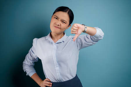Asian woman was sick with fever isolated on blue background.の写真素材