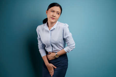 Asian woman was sick with fever isolated on blue background.の写真素材