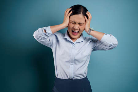 Asian woman happy surprised standing with copy space isolated on blue background.の写真素材