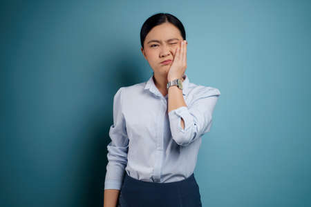 Asian woman happy surprised standing with copy space isolated on blue background.の写真素材