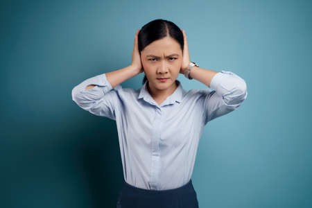 Asian woman happy surprised standing with copy space isolated on blue background.の写真素材