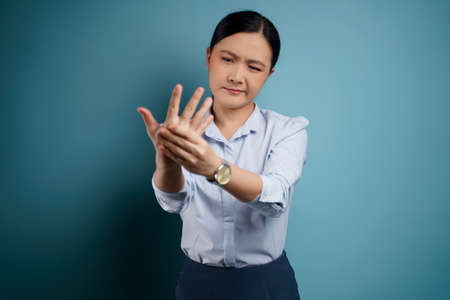 Asian woman was sick with eyes pain, irritate itching her eyes, isolated on background.の写真素材
