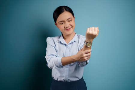 Asian woman happy confident standing showing her fist make a winning gesture isolated on blue background.の写真素材