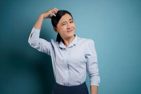 Asian woman happy surprised standing with copy space isolated on blue background.の写真素材
