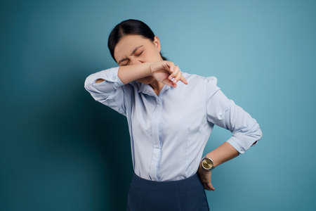 Asian woman happy surprised standing with copy space isolated on blue background.の写真素材