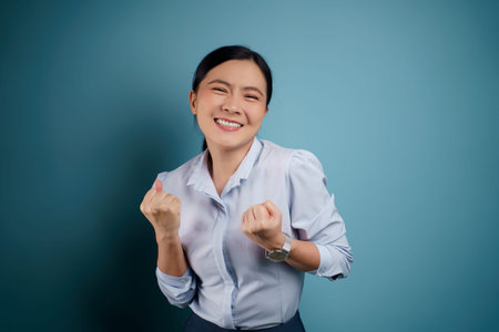 Asian woman happy surprised standing with copy space isolated on blue background.