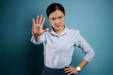 Asian woman happy surprised standing with copy space isolated on blue background.の写真素材