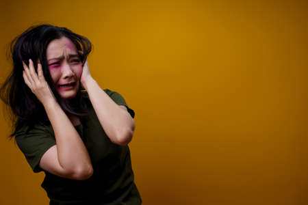 Asian woman standing and angry isolated over yellow background.の写真素材