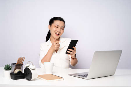 Asian woman working at officeusing smart phone for relaxing. Business with technology concepts.の写真素材